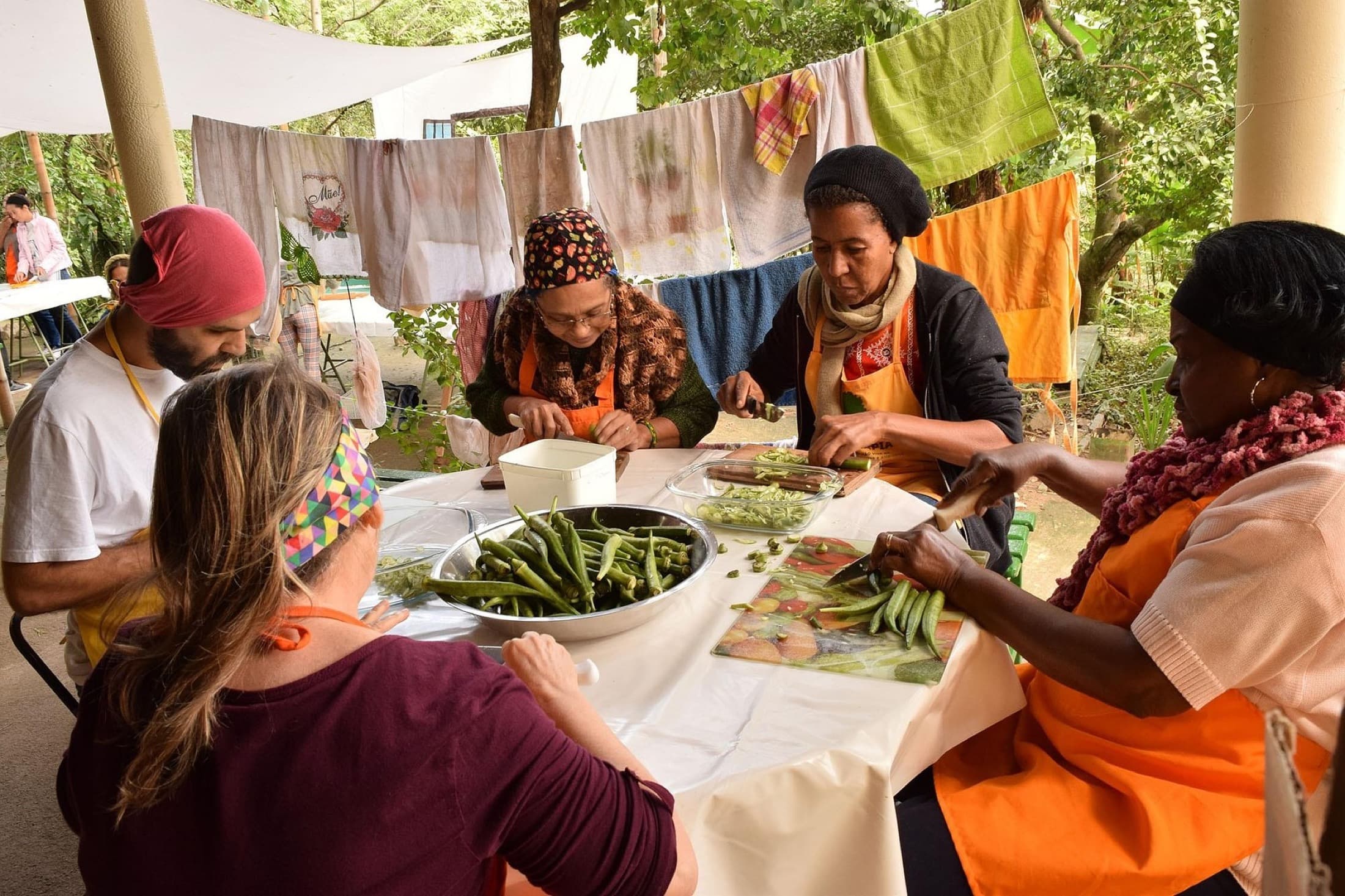 A group preparing vegetables together at an outdoor table